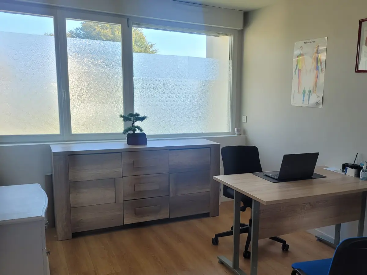 Bureau d'entretien du cabinet de Trémuson, avec planches anatomiques et lumière naturelle